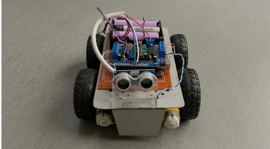 Eye Blink Controlled Car with Obstacle Avoidance built by SkillForge Technology Erode — front view showing Arduino UNO, HC-SR04 ultrasonic sensor and 18650 Li-Ion battery pack